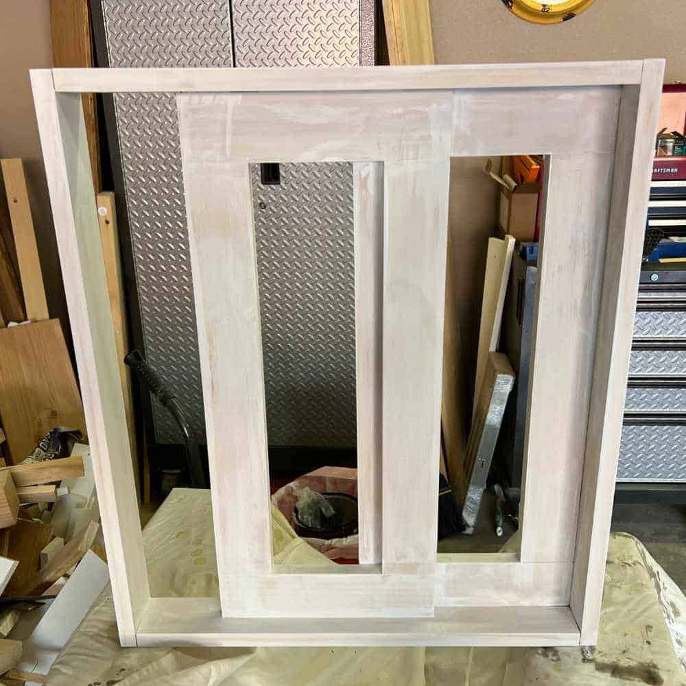 Priming a fake window frame to get it ready to paint.