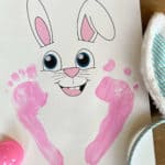 Printable page with an Easter Bunny face and painted on little kid footprints.