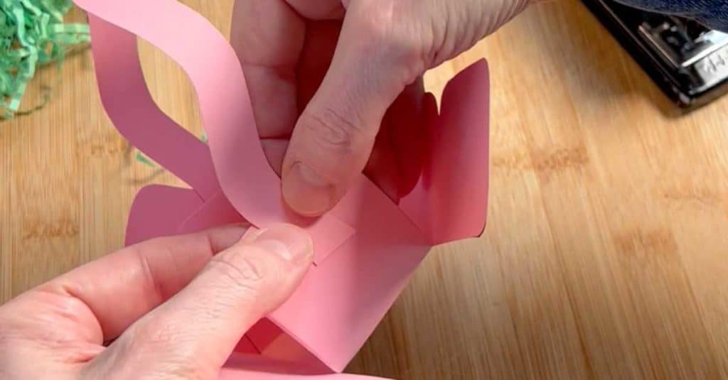 Assembling the second side of a mini paper Easter basket.