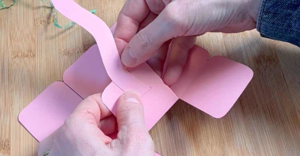 Attaching a handle to a mini paper Easter basket.