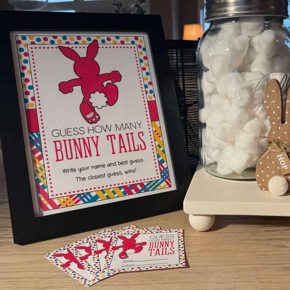 A jar full of cotton balls next to a sign that says, Guess How Many Bunny Tails.