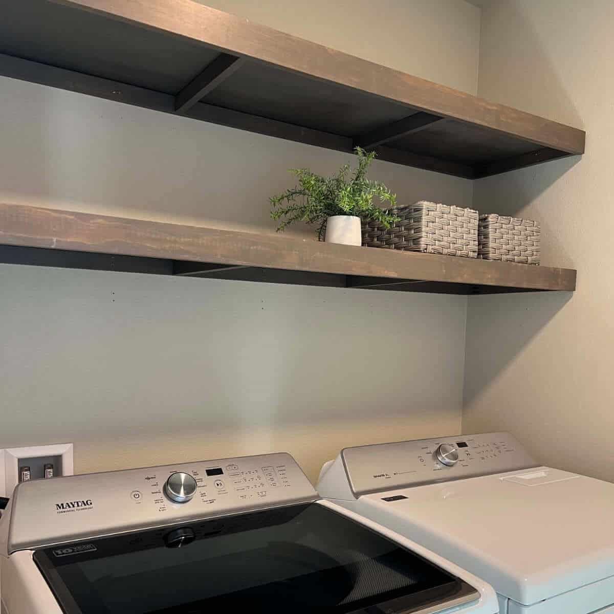 DIY laundry room shelves above a washer and dryer.