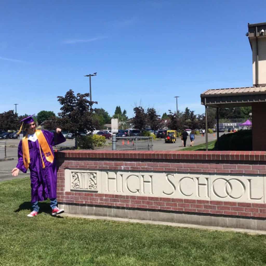 Graduate in front of his high school.