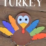Paper turkey craft made by attaching colorful feathers to a turkey.