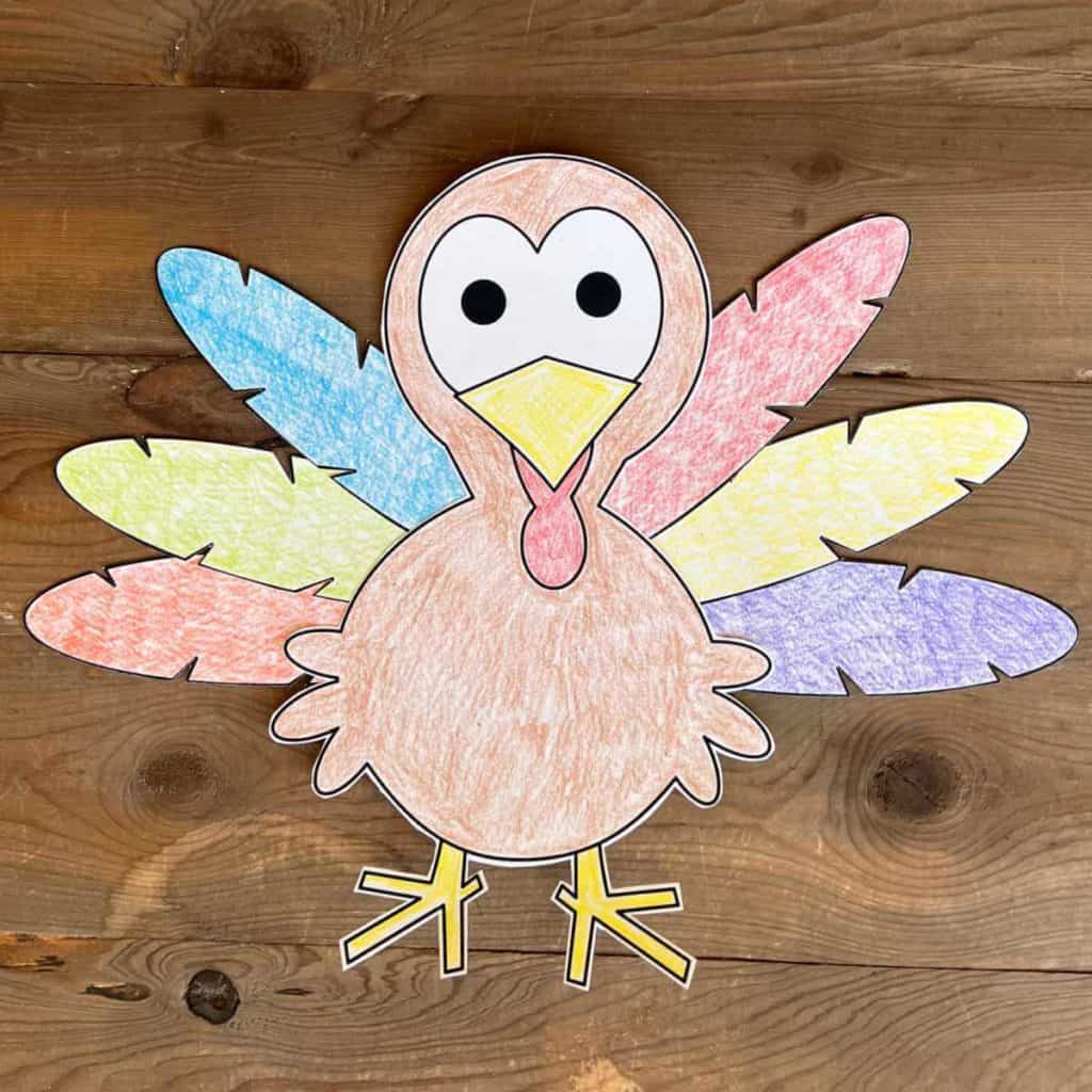 Paper turkey with colorful feathers colored with crayons.