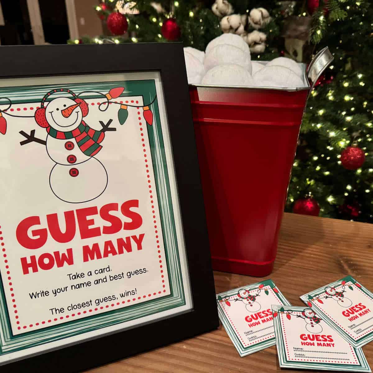 Guess How Many sign that's framed and sitting next to a bucket of fake snowballs with guess cards nearby.