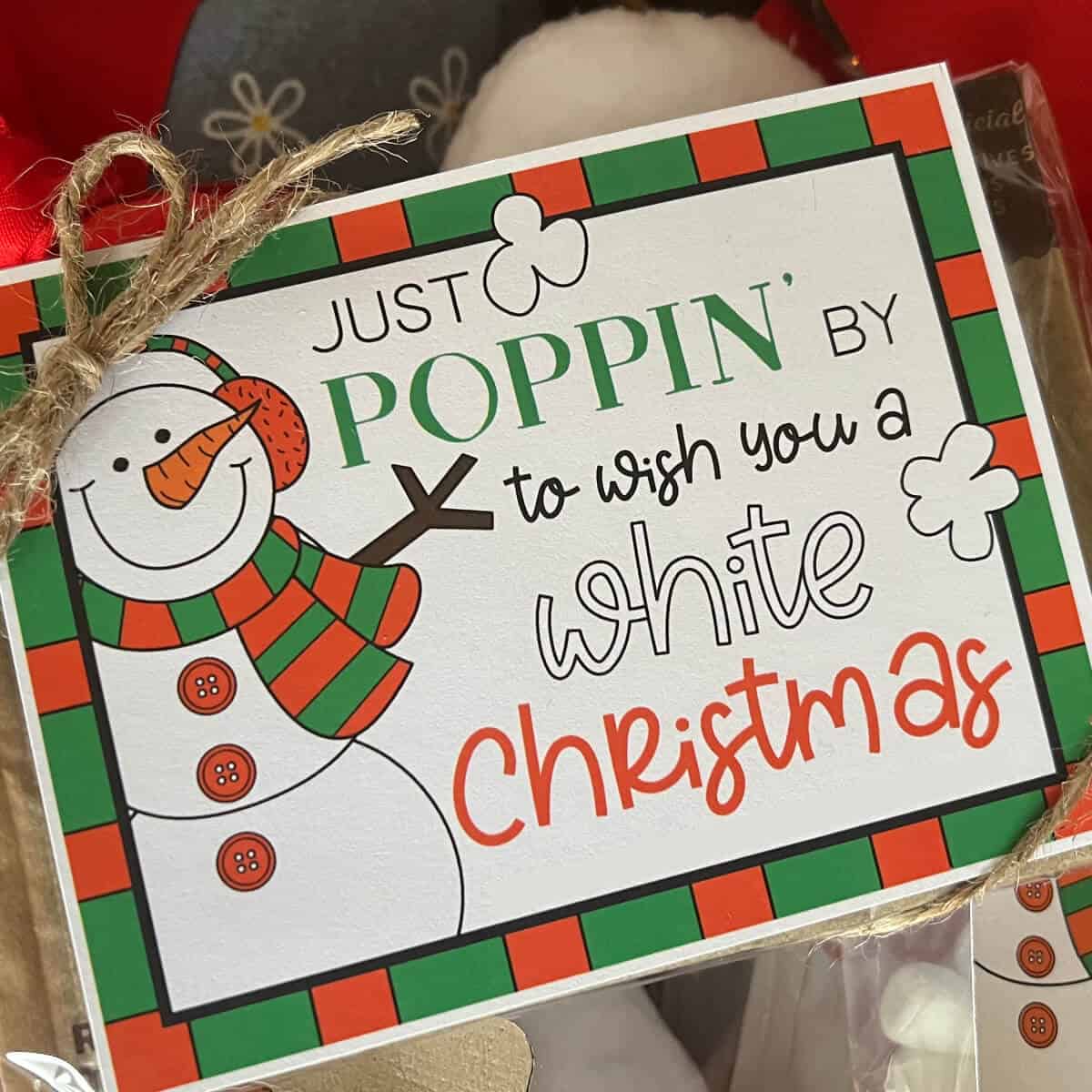 Picture of a printable White Christmas tag tied to a bag of microwave popcorn.