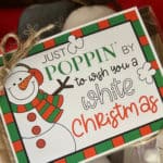 Picture of a bag of microwave popcorn with a festive White Christmas printable tag tied to the top.