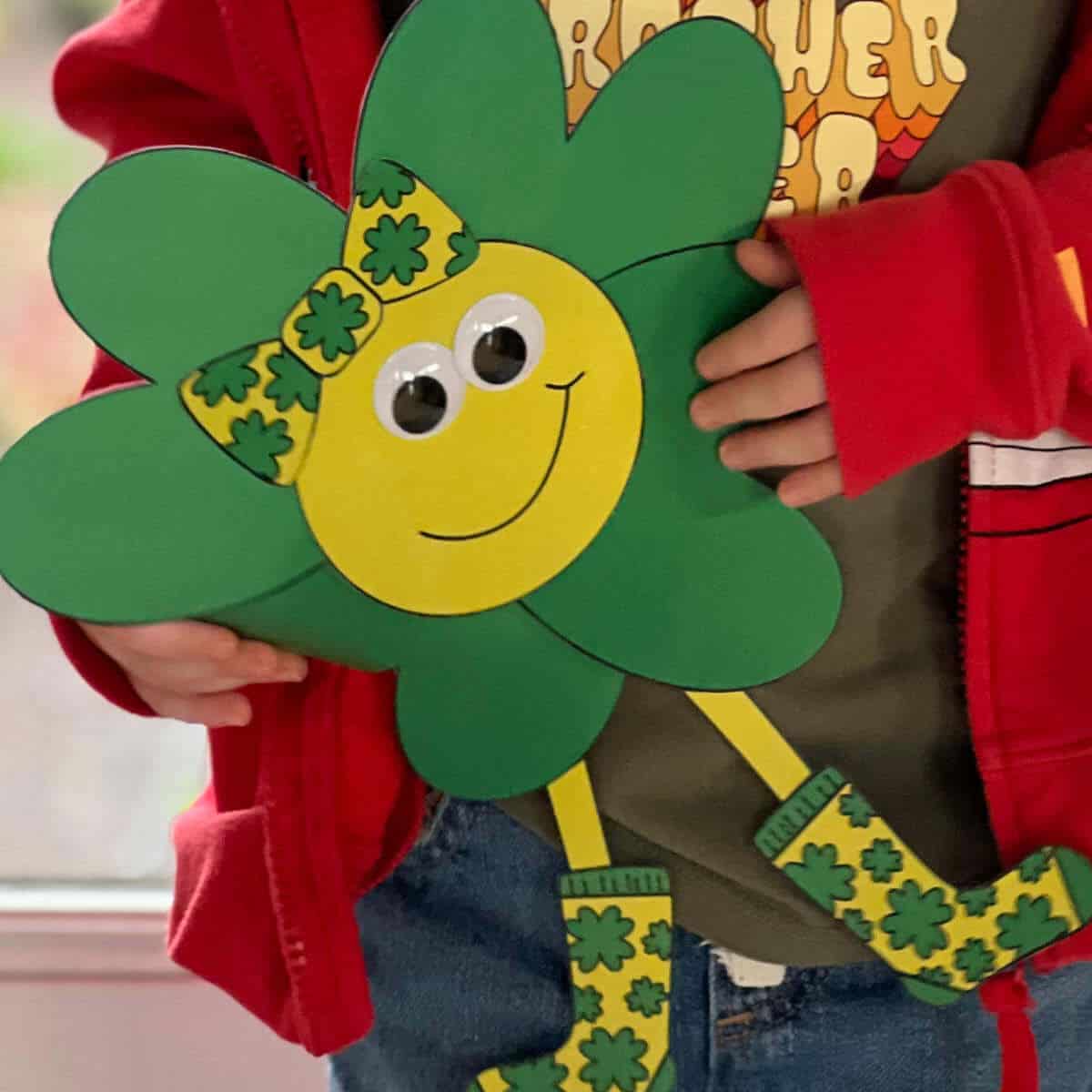 Little boy holding a four-leaf clover character craft.