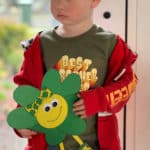 Little boy holding a four-leaf clover character craft.