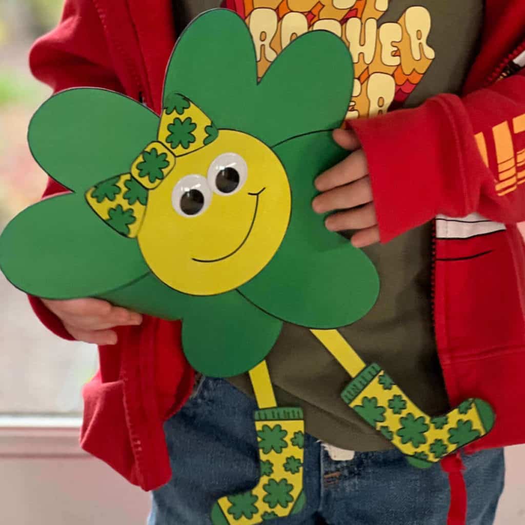 Boy holding a four-leaf clover character.