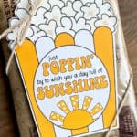 Image of a printable sunshine popcorn tag tied onto a bag of microwave popcorn.