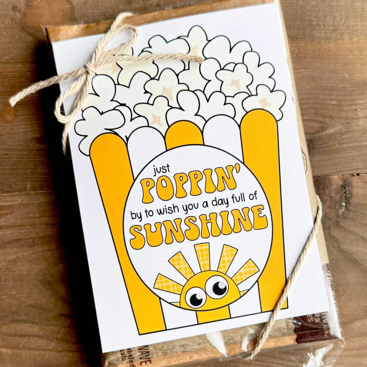 Image of a printable sunshine popcorn tag tied to a bag of microwave popcorn.