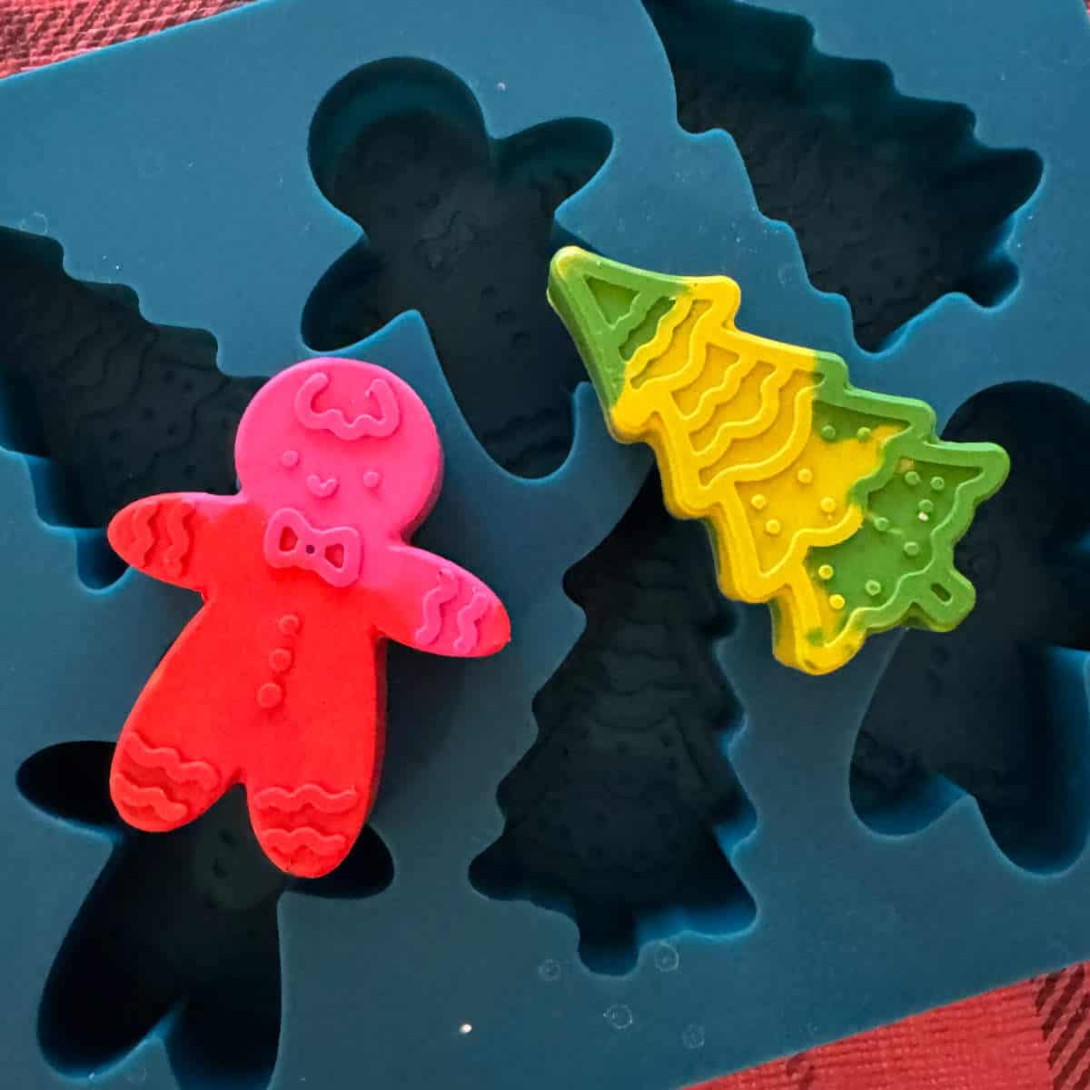 A gingerbread man and Christmas tree made out of crayons and a silicone mold.