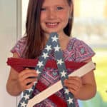 Little girl holding a patriotic star made out of paint sticks.