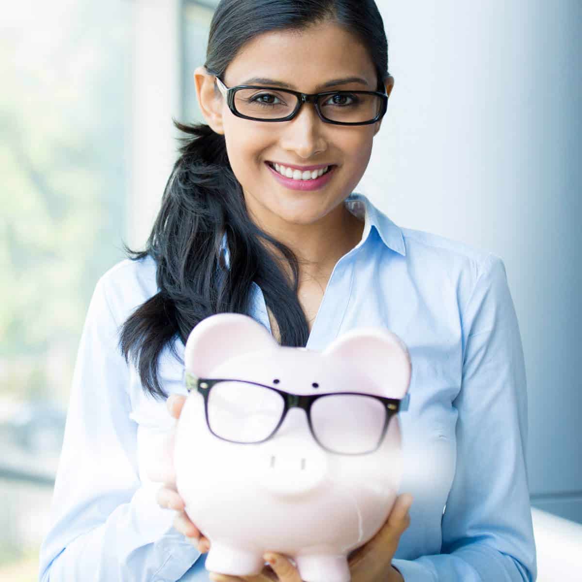 Lady wearing glasses and holding a piggy bank with glasses on.