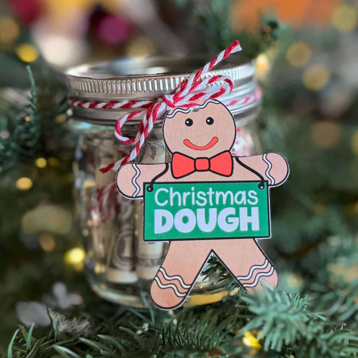 Gingerbread man tag that says Christmas Dough tied to a small jar of rolled bills.