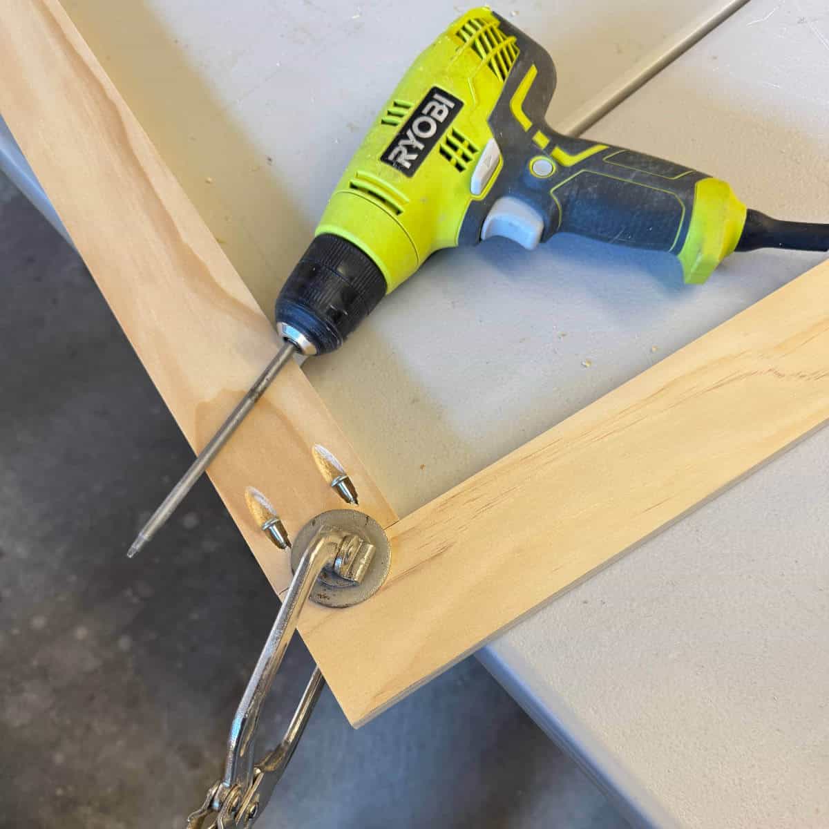 Image of two pieces of wood clamped together with a drill nearby.