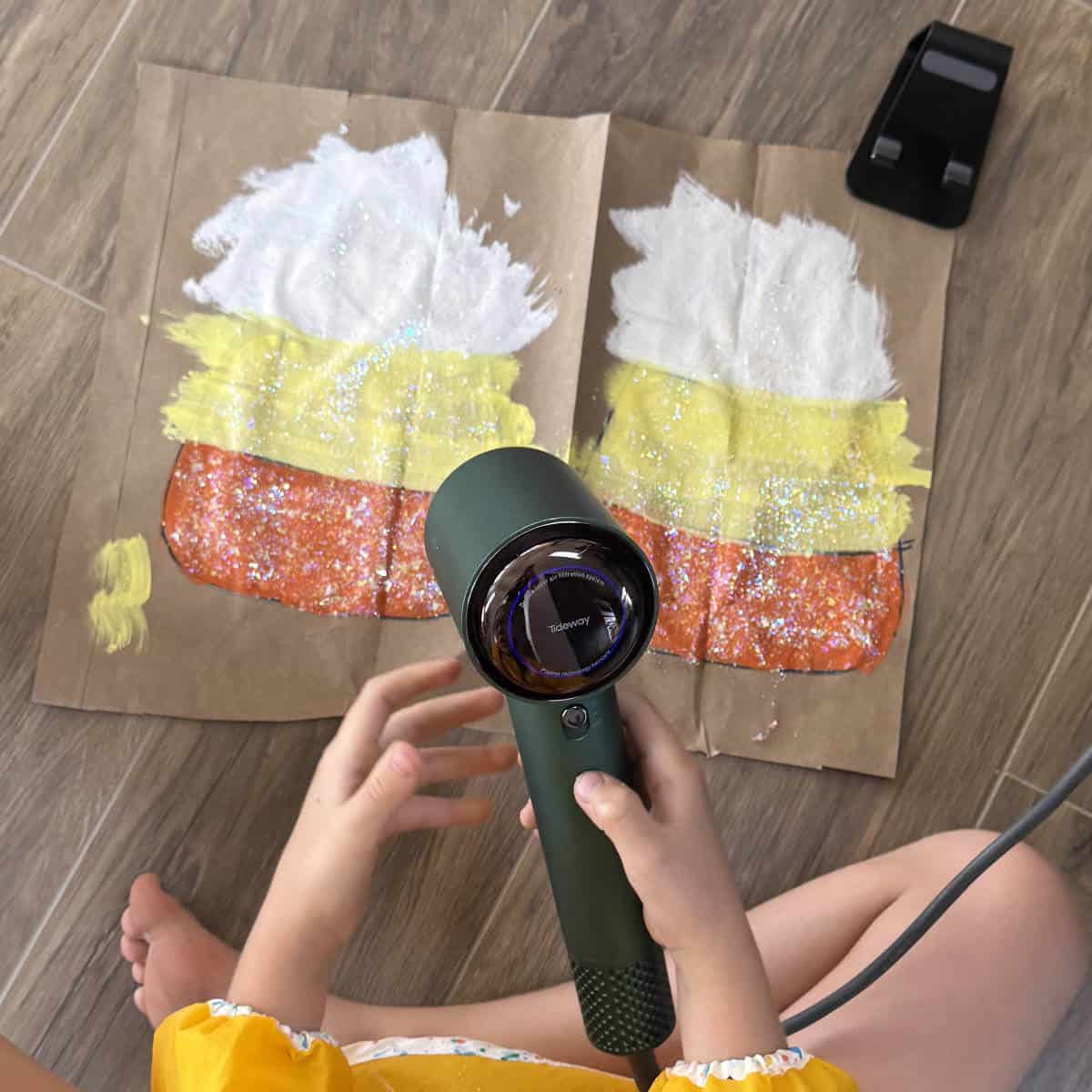 The kids wanted to use glitter paint on their paper bag candy corn decor!