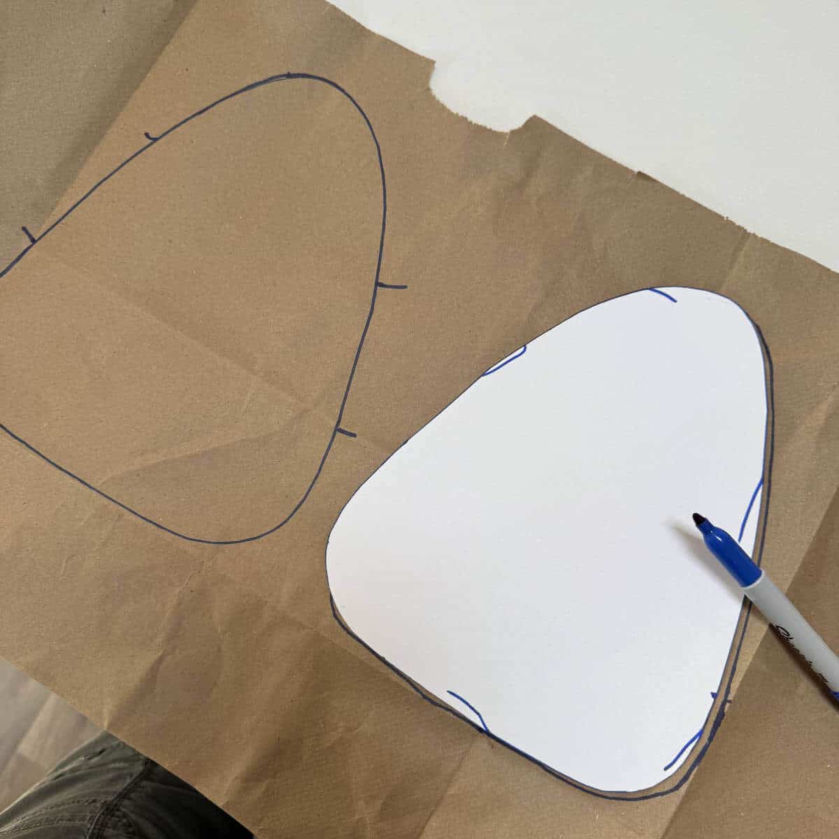 Image of a brown paper grocery bag with a candy corn template on top and a blue marker.