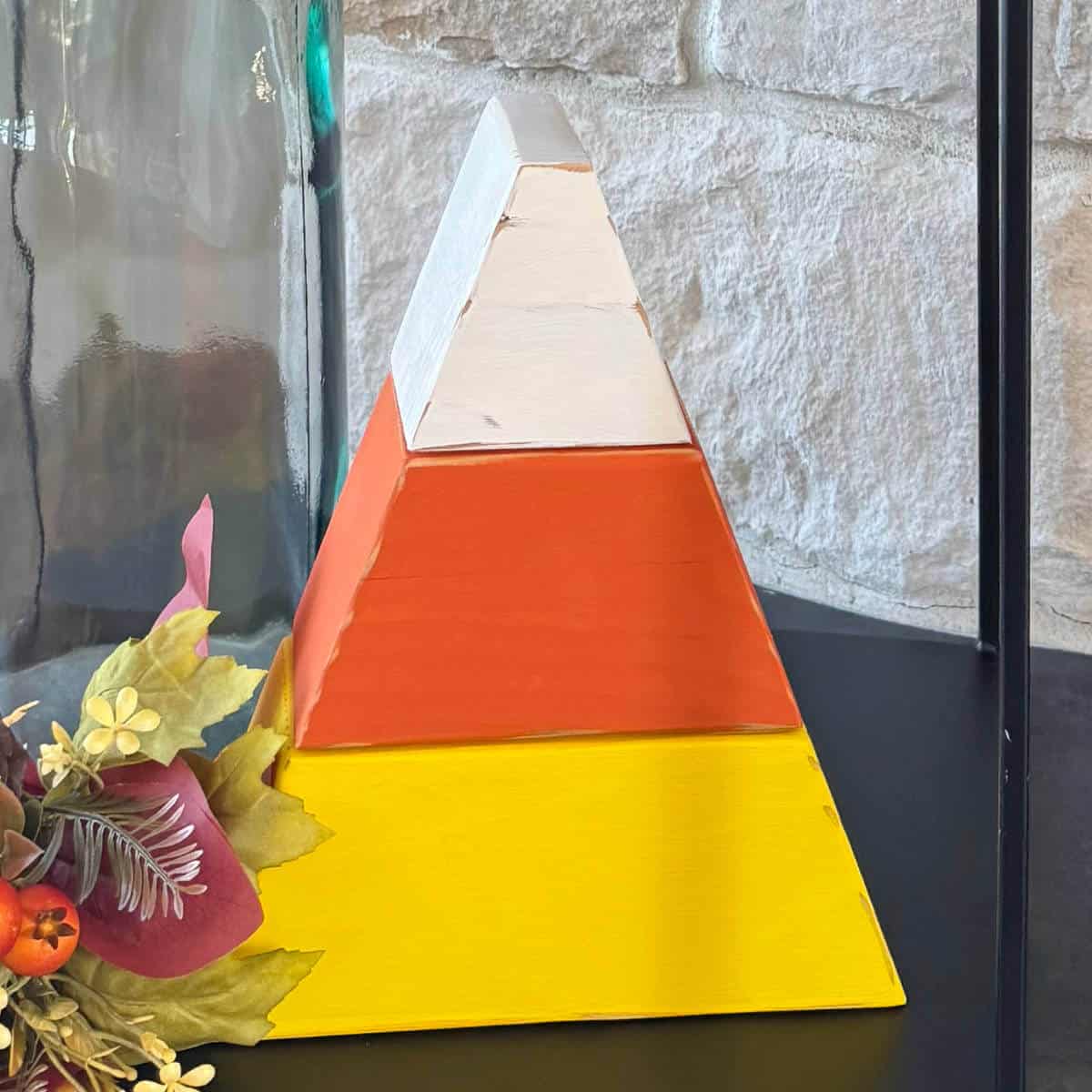 Image of a 4x4 candy corn next to some faux fall foliage.