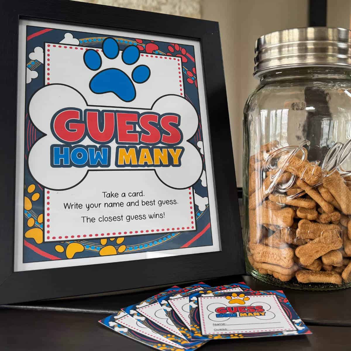 Picture of a framed Guess How Many sign next to a large jar of dog bone shaped treats.